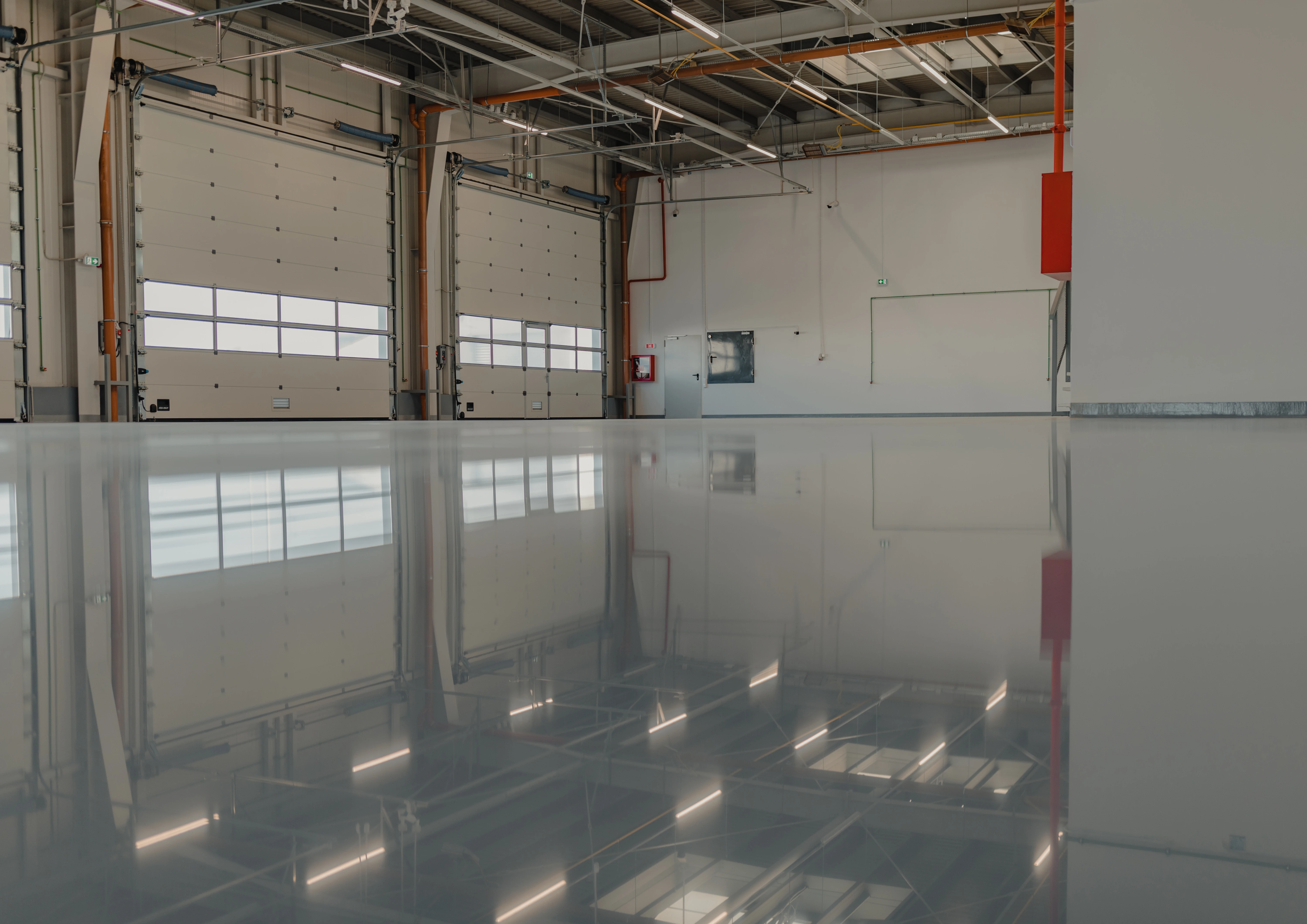 Glossy solid color epoxy floor in a large commercial workspace