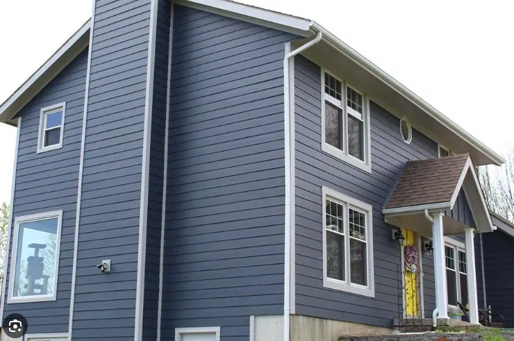 Residential exterior with blue horizontal siding and white window trim